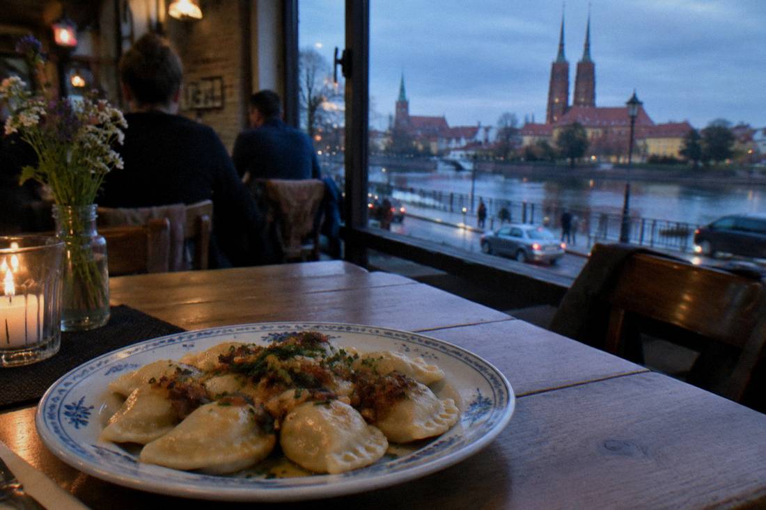 A plate of pierogi dumplings on a wooden table in a Polish restaurant
