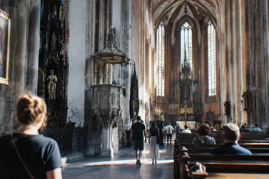 The interior of a historic Wroclaw church with high vaulted ceilings and stone columns
