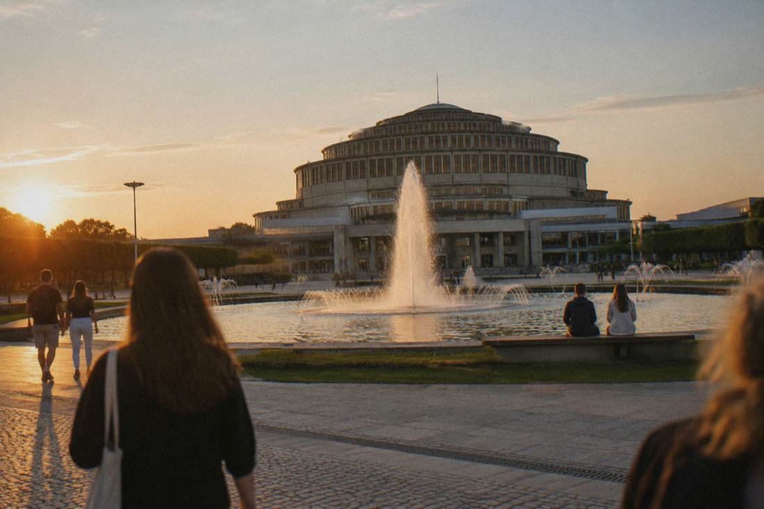 The vast concrete dome of Centennial Hall seen across a fountain and open plaza