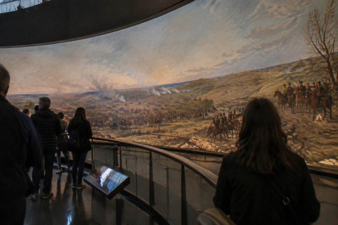 A circular viewing platform inside a rotunda with a panoramic painting wrapping around the curved wall