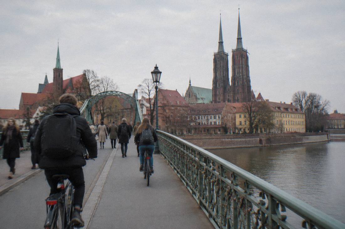 Cyclists and pedestrians on a bridge over the Odra river toward Ostrow Tumski in Wroclaw