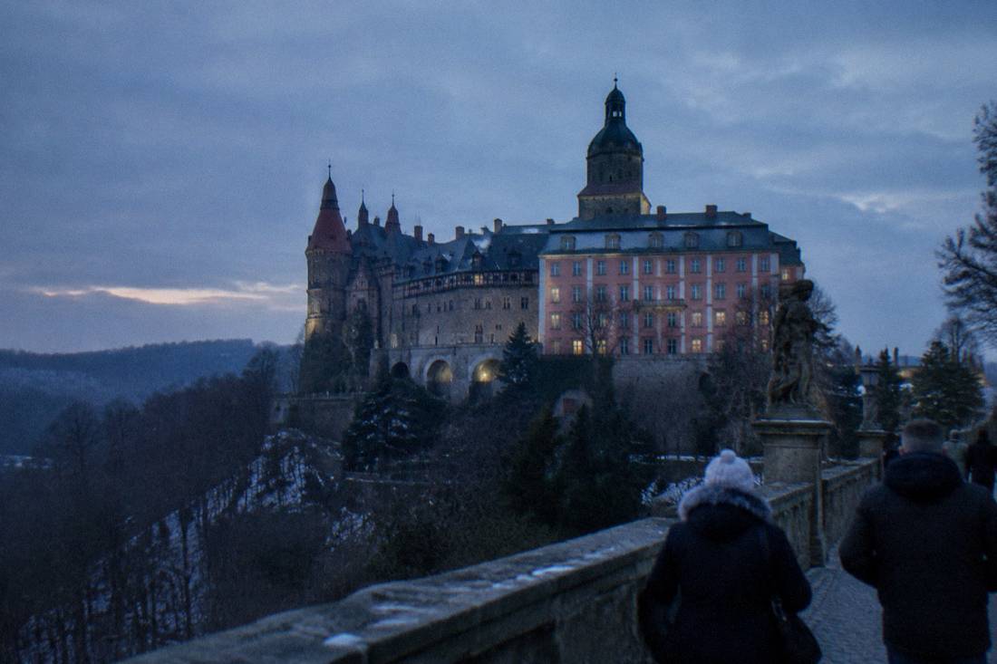 Large baroque Ksiaz Castle above forested hills in Lower Silesia under a winter sky