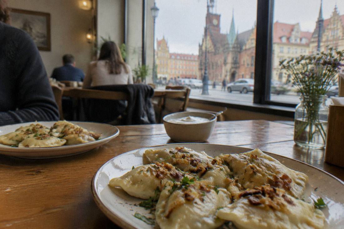 Plates of pierogi on a wooden table in a small Wroclaw restaurant